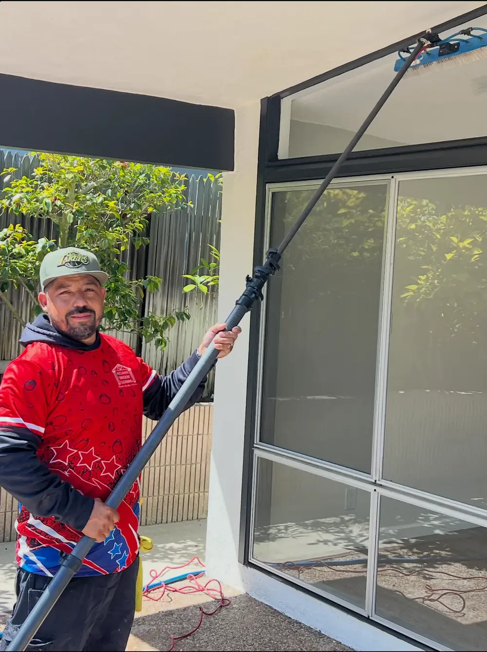 Accurate Window Cleaning technician using a pure-water reach pole